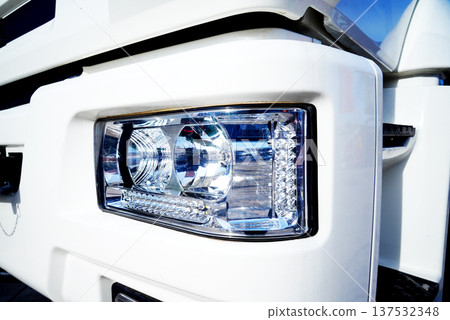 Headlight of truck close up. Close view of white truck headlight showing details of design Headlight of truck close up. Close view of white truck headlight showing details of design 137532348