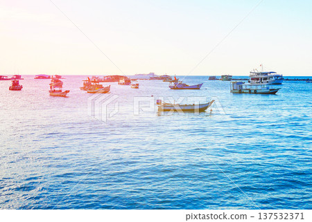 Fishing boats at shore on sunrise. Fishermen's boats in sea at shore in fishing village Fishing boats at shore on sunrise. Fishermen's boats in sea at shore in fishing village 137532371