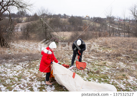 Exciting winter adventure as two children set up a tent in a snowy landscape while the sun peeks through clouds in a quaint rural area Exciting winter adventure as two children set up a tent in a snowy landscape while the sun peeks through clouds in a quaint rural area 137532527