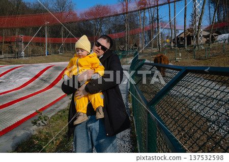 Father holding toddler at petting zoo enclosure Father holding toddler at petting zoo enclosure 137532598