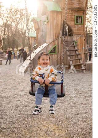 Toddler Enjoying Bucket Swing at Outdoor Playground Toddler Enjoying Bucket Swing at Outdoor Playground 137532605