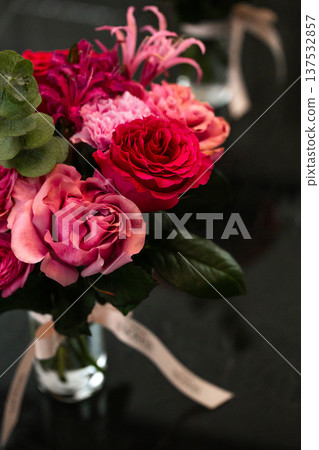 Pink rose bouquet with eucalyptus in glass vase on dark reflective surface Pink rose bouquet with eucalyptus in glass vase on dark reflective surface 137532857