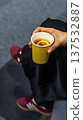 Hand Holding Yellow Paper Cup with Hot Lemon Tea 137532887