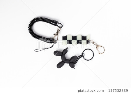 Black and White Checkered Flag and Balloon Dog Keychains on White Background Black and White Checkered Flag and Balloon Dog Keychains on White Background 137532889