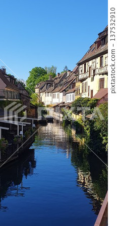 Phone photo of the canal in Little Venice in Colmar with lush spring greenery. Scenic riverside view showing historic architecture, nature, and calm seasonal atmosphere. 137532910