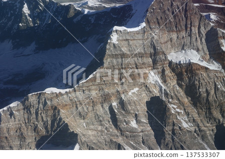 A view of the Himalayan mountains from the window of a mountain flight, with the geological layers visible on the mountainside 137533307
