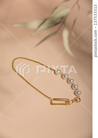 Sophisticated Jewelry Setup Showcasing Pearl Link Necklace With Leaf Shadow On Peach Background Sophisticated Jewelry Setup Showcasing Pearl Link Necklace With Leaf Shadow On Peach Background 137533313