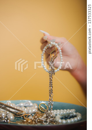 Stylist Arranges Luxurious Jewelry Pieces. Pearl Bracelet Showcased Above Curated Jewel Collection Stylist Arranges Luxurious Jewelry Pieces. Pearl Bracelet Showcased Above Curated Jewel Collection 137533325