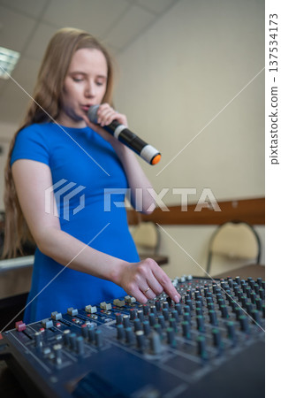 Young woman mixing live sound. Girl recording a song in the studio. Young woman mixing live sound. Girl recording a song in the studio. 137534173
