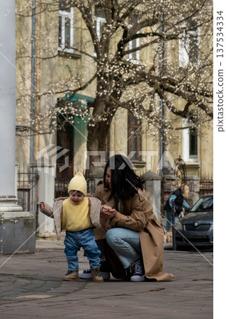 Mother and toddler under blossoming tree Mother and toddler under blossoming tree 137534334