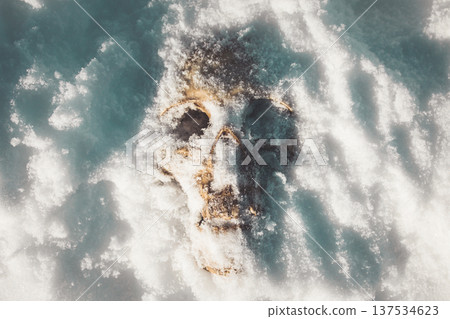 A human skull under snow. An eerie concept, buried in cold snow. Archaeological excavations, human remains. Dark winter concept of death, accident. Skull close-up. 137534623