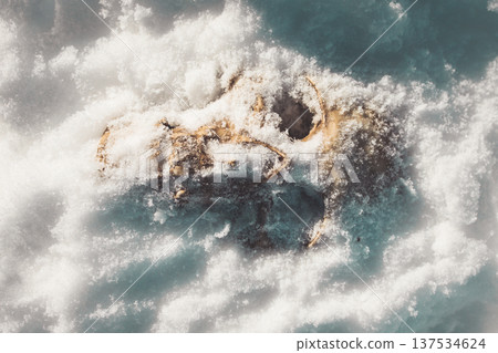 A human skull under snow. An eerie concept, buried in cold snow. Archaeological excavations, human remains. Dark winter concept of death, accident. Skull close-up. 137534624