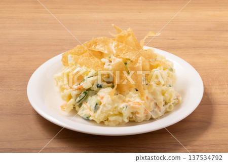 Potato salad and fried spring roll skins 137534792