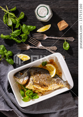 Baked whole dorada fish with lemon and basil Baked whole dorada fish with lemon and basil 137535160