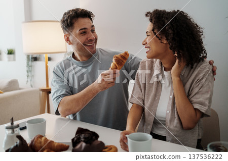 Friendly Breakfast Moment. Couple Share Pastries And Smiles. Joyful Morning With Treats And Warm Laughter Friendly Breakfast Moment. Couple Share Pastries And Smiles. Joyful Morning With Treats And Warm Laughter 137536222