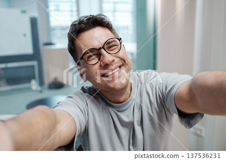 Modern Office Scene Capturing Cheerful Manager Communicating Team Updates Via Mobile Device 137536231