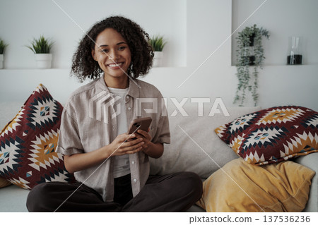 Content Female Individual Relaxing In Cozy Setting With Decorative Cushions And Lush Indoor Plants Content Female Individual Relaxing In Cozy Setting With Decorative Cushions And Lush Indoor Plants 137536236