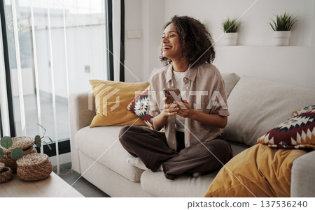 Person Calmly Holding Steaming Coffee While Gazing Through Window In Peaceful Living Room Environment 137536240