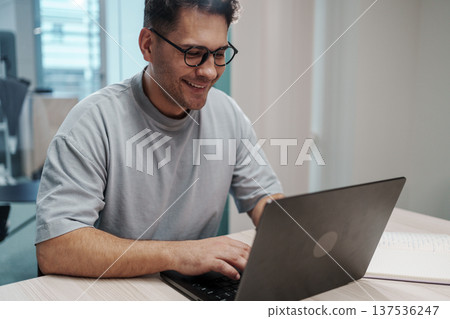 Male Expert Carefully Analyzing Charts And Documents In Professional Setting With Dedication 137536247