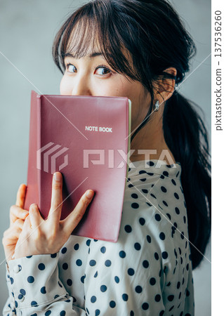 A young lady with a notebook 137536260