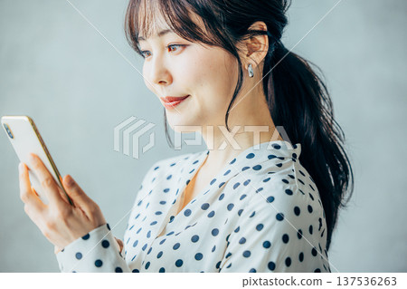 一個操作智能手機的年輕女子 137536263
