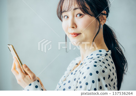 一個操作智能手機的年輕女子 137536264