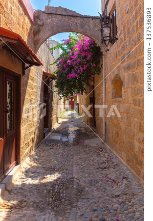 Narrow medieval street with stone arch in Rhodes Old Town Greece 137536893