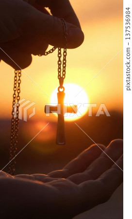 Adult Hands Holding Cross Necklace At Sunset Adult Hands Holding Cross Necklace At Sunset 137536984