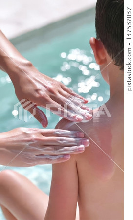Applying Sunscreen to Child by Poolside Applying Sunscreen to Child by Poolside 137537037
