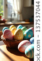 Basket of Pastel Easter Eggs on Sunlit Table 137537044