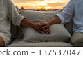Couple Holding Hands on Sofa at Sunset 137537047