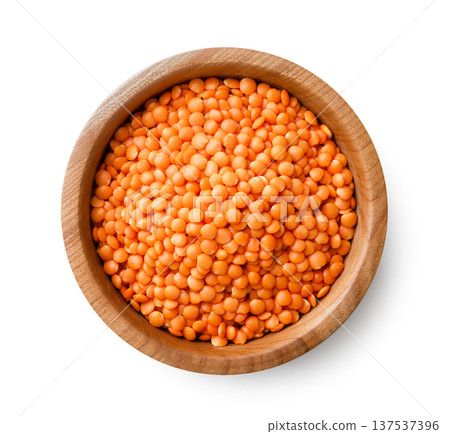 Red lentils in a wooden plate close-up on a white. Top view Red lentils in a wooden plate close-up on a white. Top view 137537396