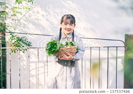 Girl holding vegetables in the garden 137537486