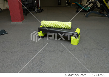 Foam roller and aerobic step on gym floor with fitness equipment 137537530