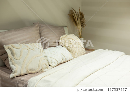 Cozy bedroom with soft pillows and neutral bedding Cozy bedroom with soft pillows and neutral bedding 137537557