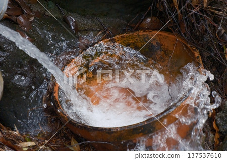 An old bowl that collects spring water 137537610