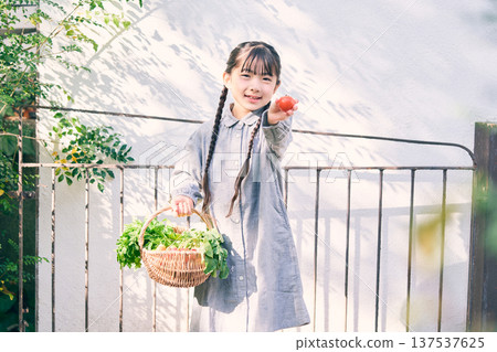 Girl holding vegetables in the garden 137537625
