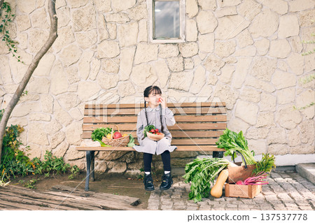 Girl sitting on a bench with vegetables 137537778