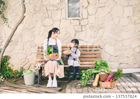 Girl sitting on a bench with vegetables Girl sitting on a bench with vegetables 137537824