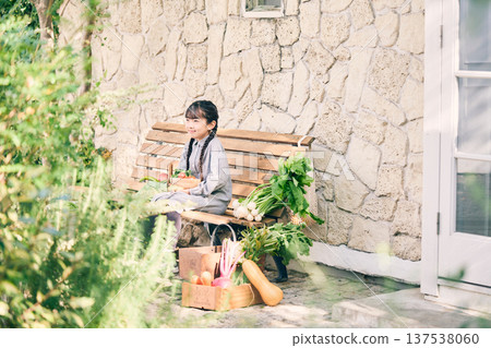 Girl sitting on a bench holding vegetables 137538060