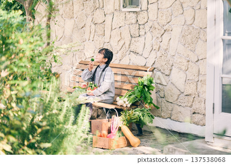 女孩坐在長椅上,手裡拿著蔬菜 女孩坐在長椅上,手裡拿著蔬菜 137538068