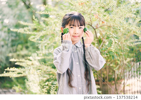 女孩在花園裡拿著蔬菜 女孩在花園裡拿著蔬菜 137538214