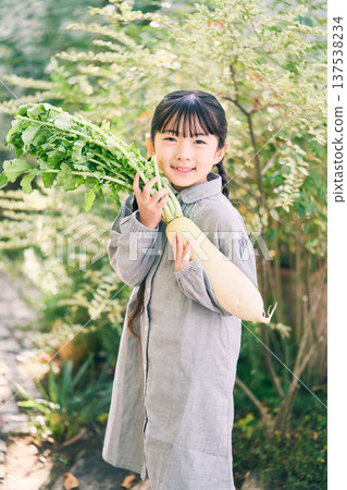 Girl holding radish in the garden 137538234