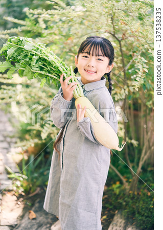 Girl holding radish in the garden 137538235
