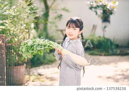 Girl holding radish in the garden Girl holding radish in the garden 137538238