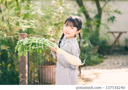 Girl holding radish in the garden Girl holding radish in the garden 137538240