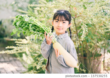 Girl holding radish in the garden Girl holding radish in the garden 137538255