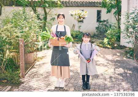 父母和孩子在花園裡拿著蔬菜 137538396