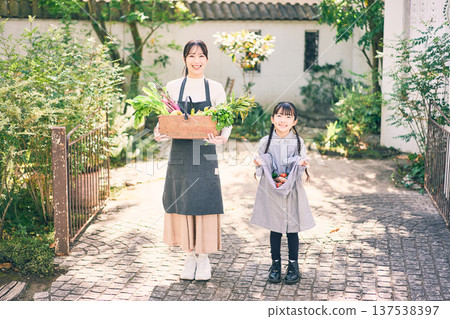 父母和孩子在花園裡拿著蔬菜 137538397