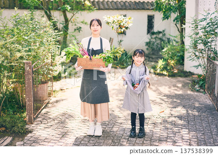 Parents and children holding vegetables in the garden Parents and children holding vegetables in the garden 137538399